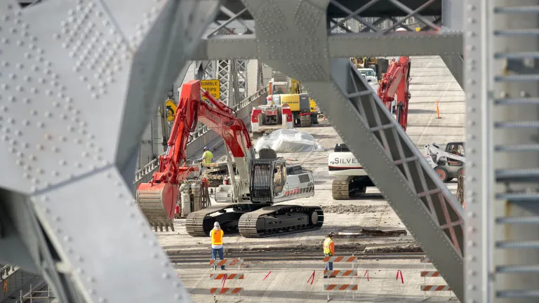 Using excavators, crews lift up chunks of deck and deposit them into trucks, being careful to contain the debris so as to avoid polluting the Bay below. 