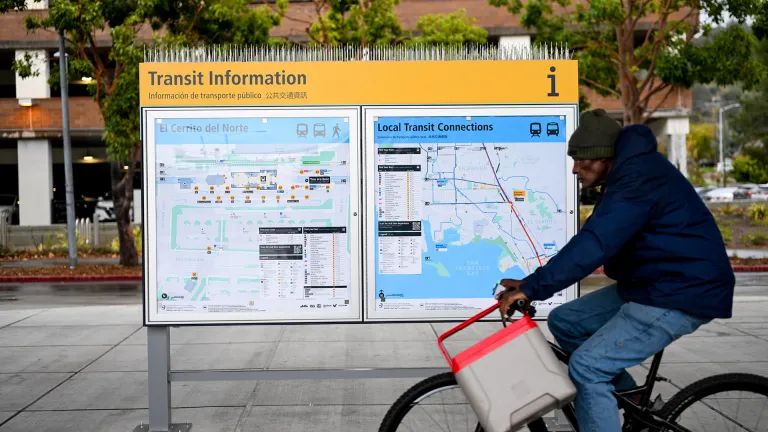 A cyclist rides past a new Transit Information sign at El Cerrito del Norte BART station.