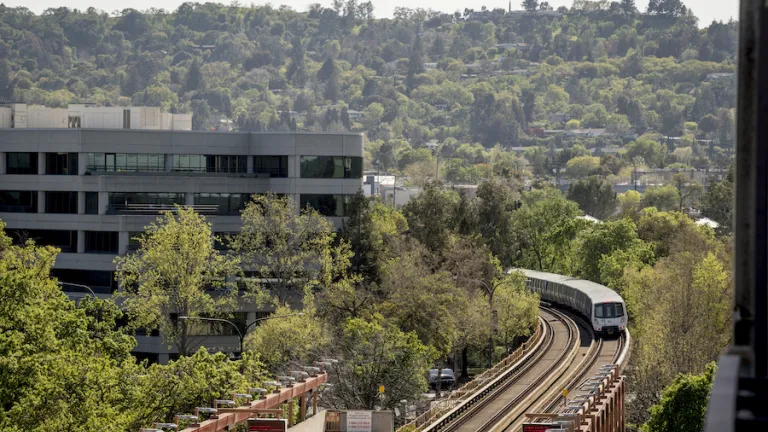 An aerial view of a BART train approaching Pleasant Hill station.