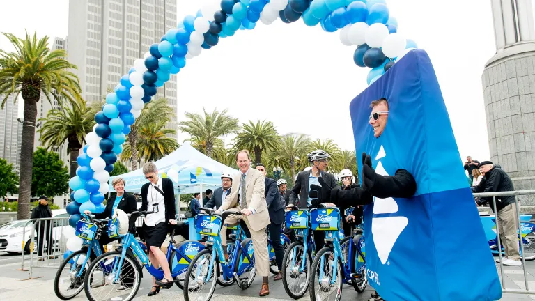 people on go bikes under a balloon arch