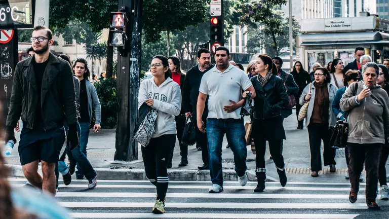 Pedestrians cross the street in the crosswalk.