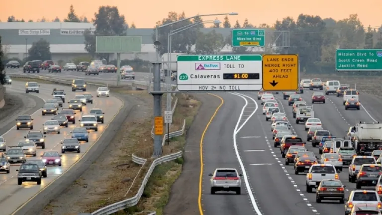 Traffic stands at a halt while a single car moves freely in the express lane.