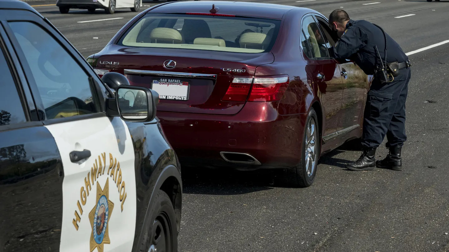 A California Highway Patrol officer speaks to a roadside motorist.