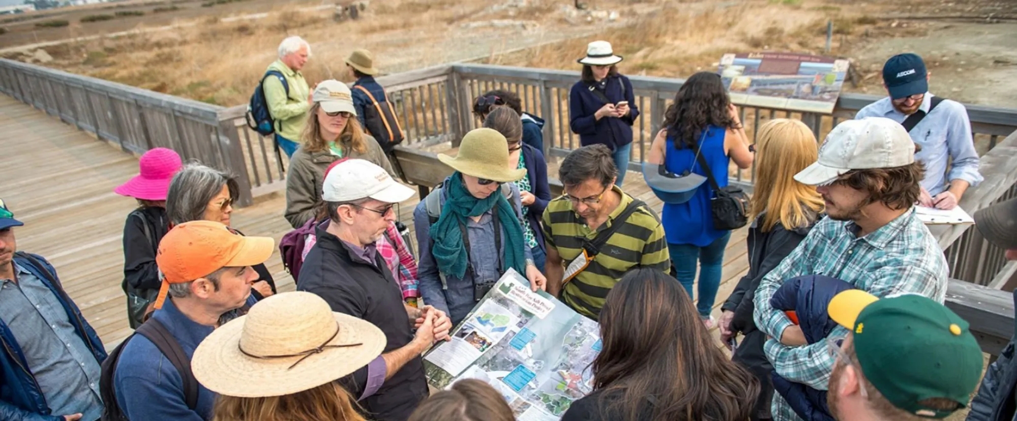 Design team members peruse a large brochure of the South Bay Salt Ponds