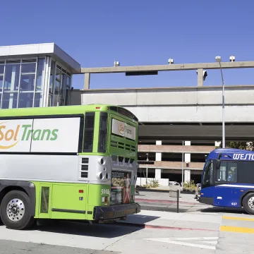 A SolTrans bus and a WestCAT bus at the El Cerrito del Norte BART station.