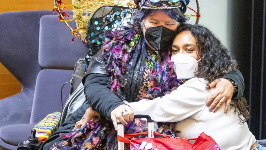 Two people in wheelchairs hugging at the Accessible Futures Conference.