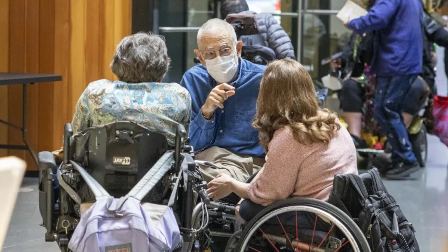 Three people in wheelchairs in conversation at the Accessible Futures Conference.