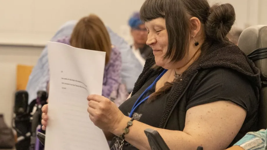 An Accessible Futures Conference attendee reading the draft conference resolution.