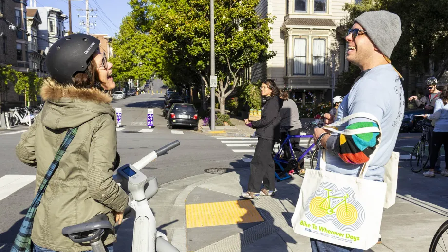 People chatting happily at a Bike to Wherever Days 2025 energizer station in San Francisco.