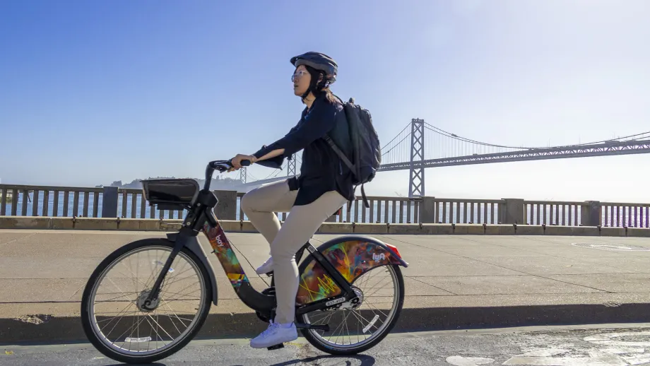 A cyclist on a Bay Wheels bikeshare bike on the San Francisco waterfront.