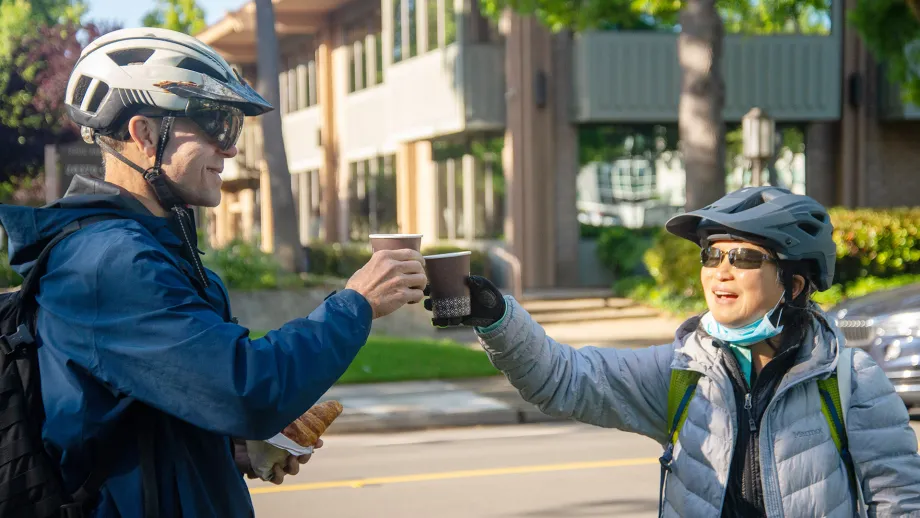 Cyclists toasting cups of coffee at an energizer station on Bike to Wherever Day 2025.