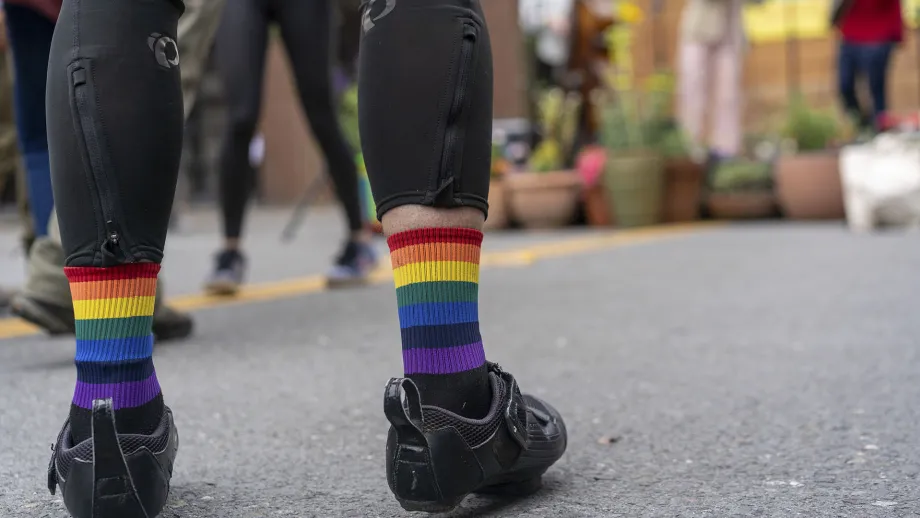 Detail of a cyclist's rainbow striped socks.