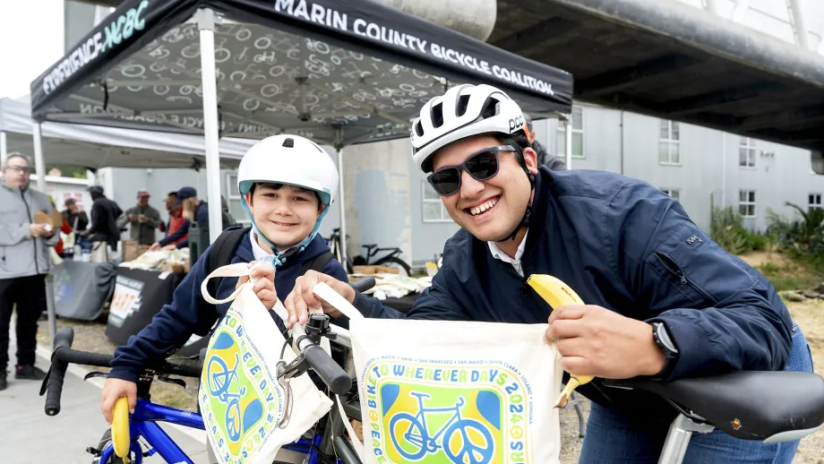 A smiling adult and child at the Larkspur Bike to Work Day Energizer Station.