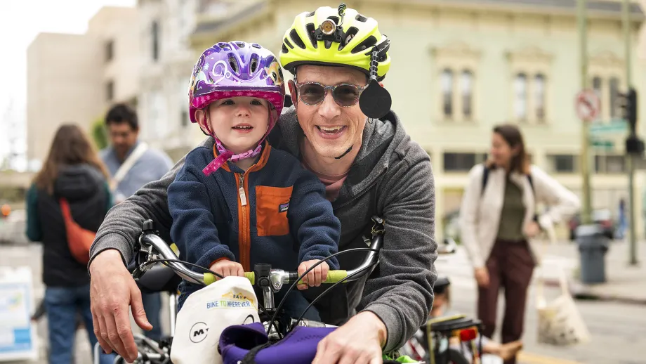 A smiling adult and child at on Bike to Work Day.