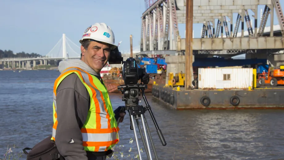 Man taking photo of Truss being moved on a barge