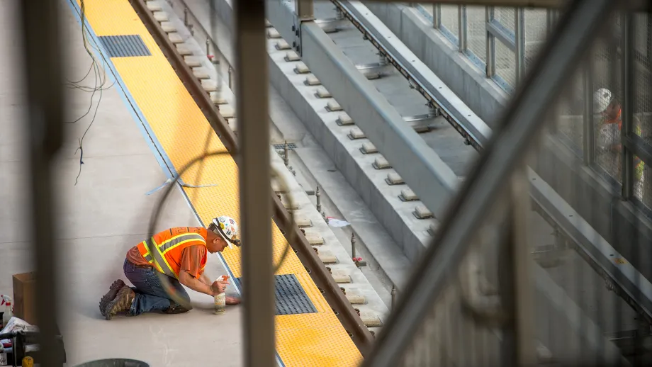 Warm Springs BART Station: Worker caulks a gap near the tracks.