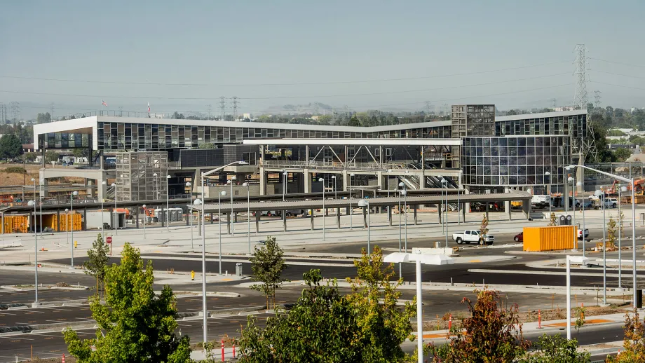 Warm Springs BART Station: View shows station from afar with the parking lot on the front and the rotunda on the far right.