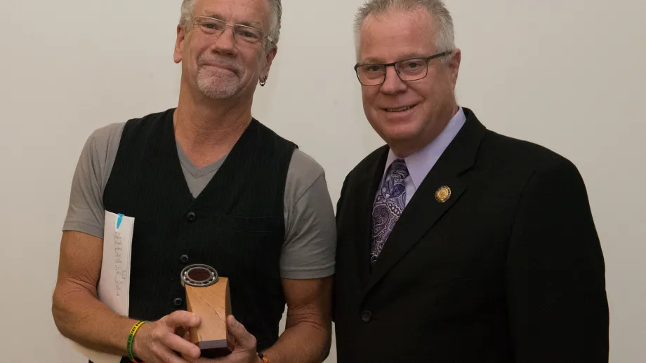 Billy Bradford, Miriam L. Gholikely Public Service Award winner, holds his trophy and poses for a photo next to MTC Commissioner Scott Haggerty