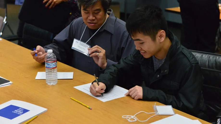 men writing at a table