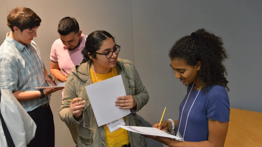 group of people talking and taking notes