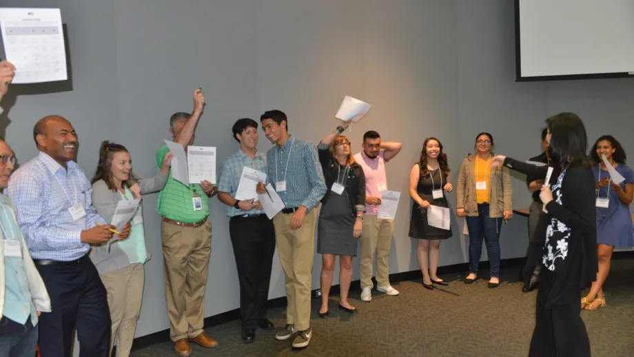 group of people lined up with papers in their hands