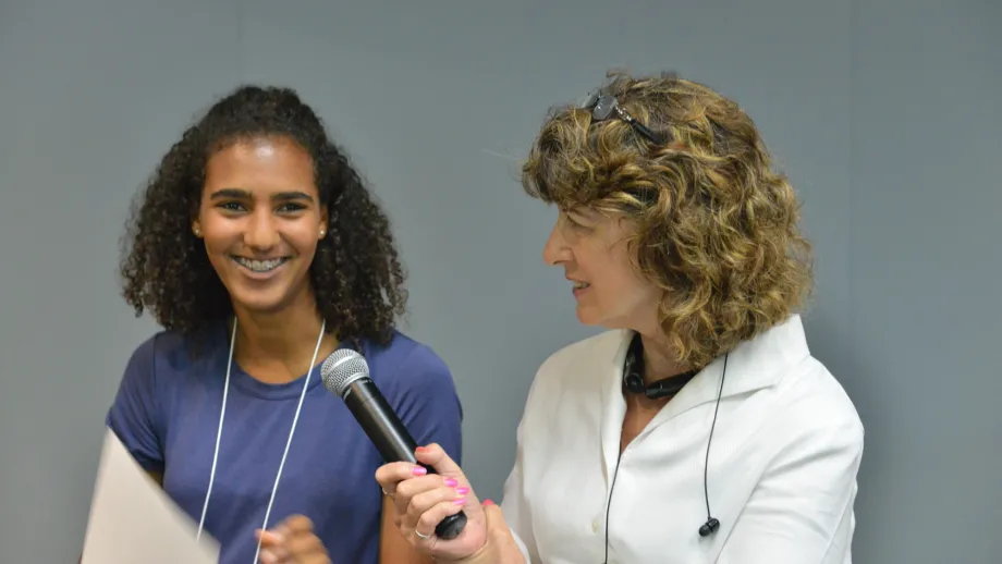 woman holding a microphone up to another woman