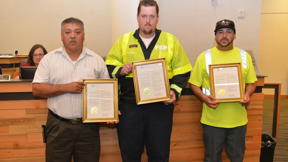 Freeway Service Patrol tow truck drivers Moises Reyes and Darryl Poe with Waste Management of Alameda County driver David Garcia with their awards