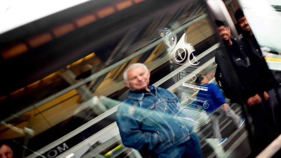 man looking at car with hands in his pockets