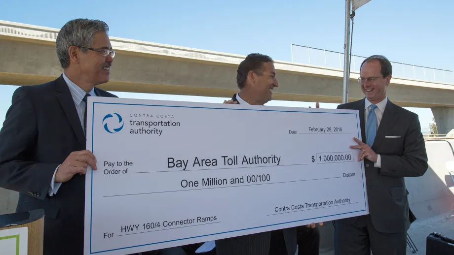 3 men holding giant check