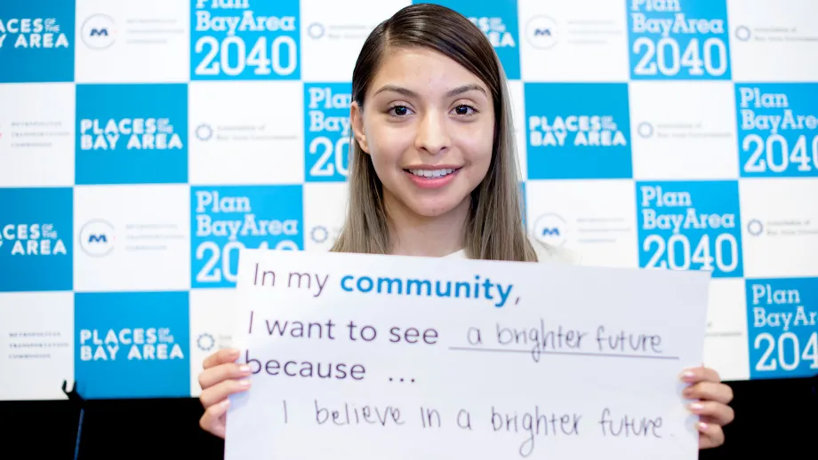 person holding a sign that reads I love my community because