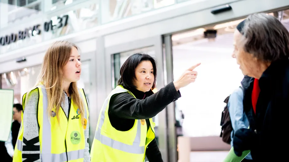 AC Transit ambassadors help a commuter navigate the Salesforce Transit Center during the first day of AC Transit Service