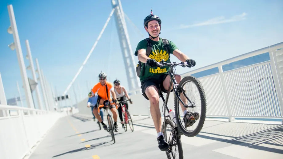 man popping a wheelie across the East span path