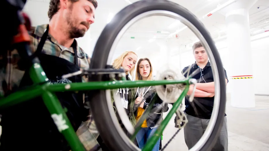 people gathered around a bicycle wheel