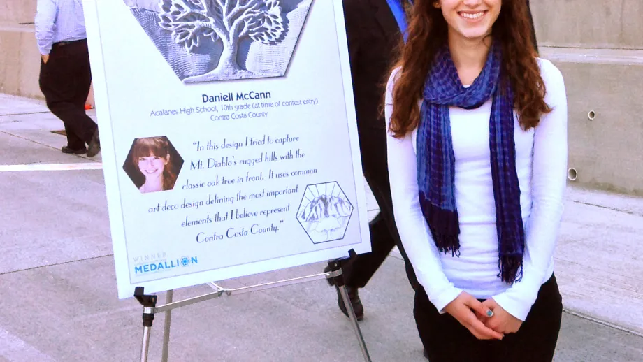   Artist Daniell McCann poses by her medallion design.