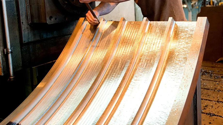 A worker checks specifications on a piece of the Bay Bridge's steel saddle.