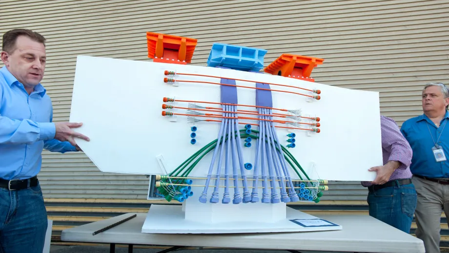 Bill Casey demonstrates a model of post-tensioned tendons that will reinforce the East Span.