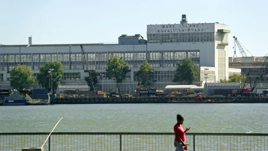 A pedestrian passes a vista of Mare Island on Wednesday, Aug. 31, 2013, in Vallejo, Calif. XKT Engineering, located at the former naval shipyard, is fabricating a steel saddle that will reinforce the Bay Bridge's new East Span.