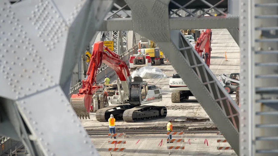 Using excavators, crews lift up chunks of deck and deposit them into trucks, being careful to contain the debris so as to avoid polluting the Bay below. 
