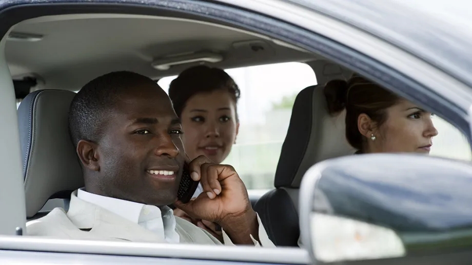 Three happy adults sharing a carpool ride together.