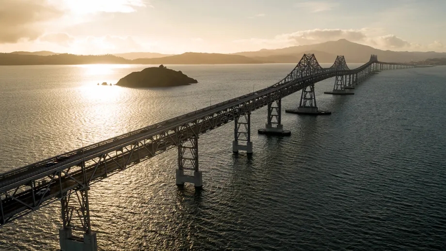 Aerial of the Richmond-San Rafael Bridge at twilight, with a dramatic sky.