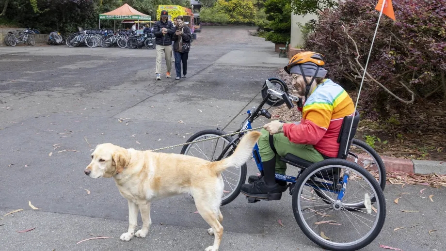 A wheelchair user riding a hand-cycle bicycle provided for free through the Adaptive Bicycling program in Golden Gate Park.