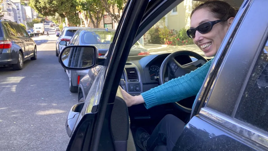 A woman using the Dutch Reach to safely open her vehicle door.