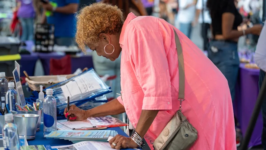 A woman writing comments at a Plan Bay Area 2050+ pop up workshop.