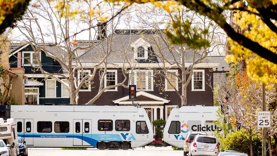 VTA light rail train near a large home on a residential street.