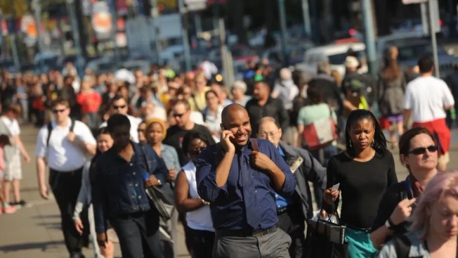 People walking on a city street during the commute hours.